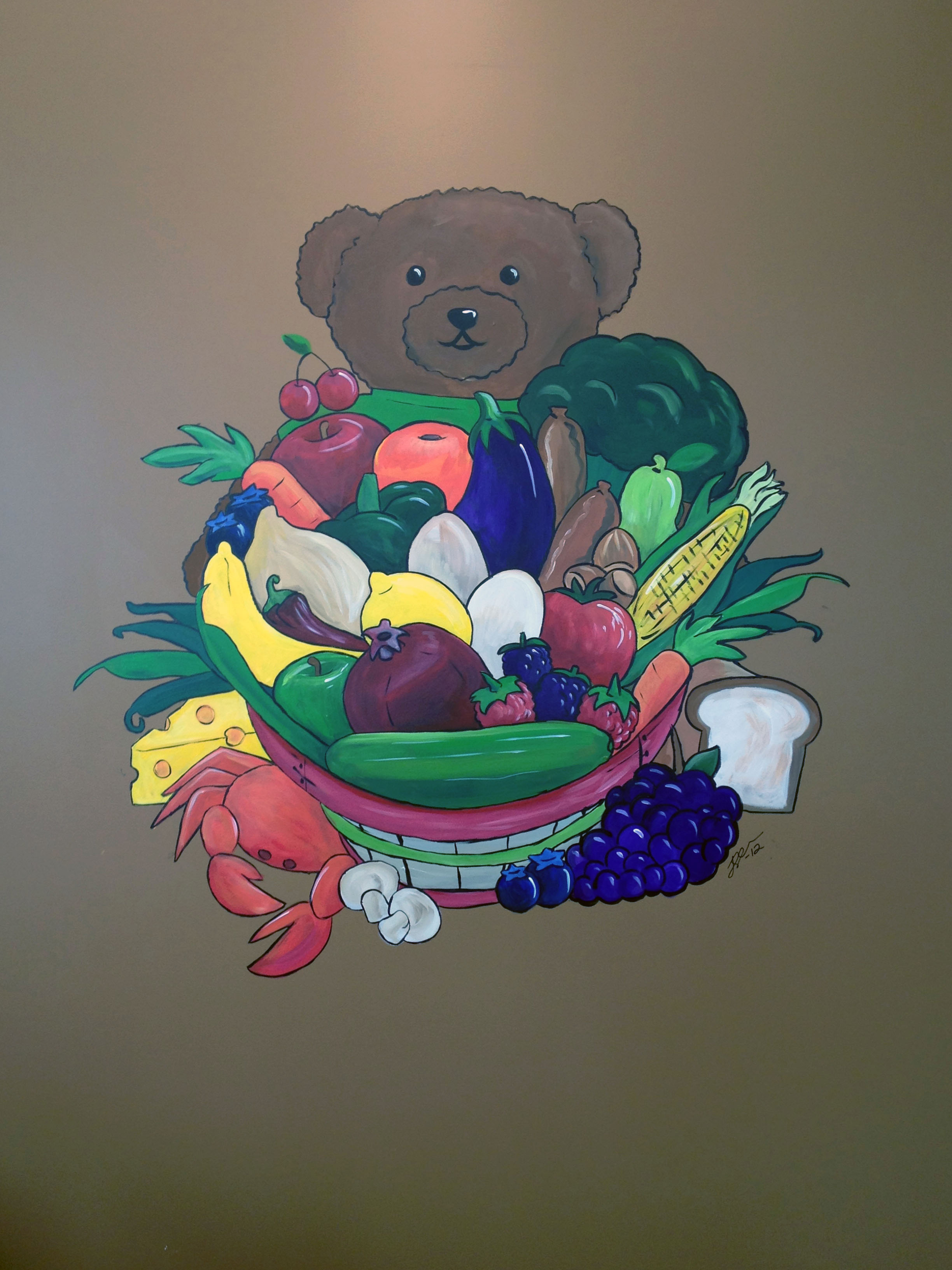 Joshann painting mural of a bear holding a basket of fruits and vegetables 3